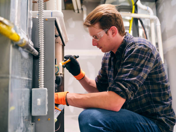 HVAC Technician Inspecting Indoor Furnace Electrical Components During Maintenance